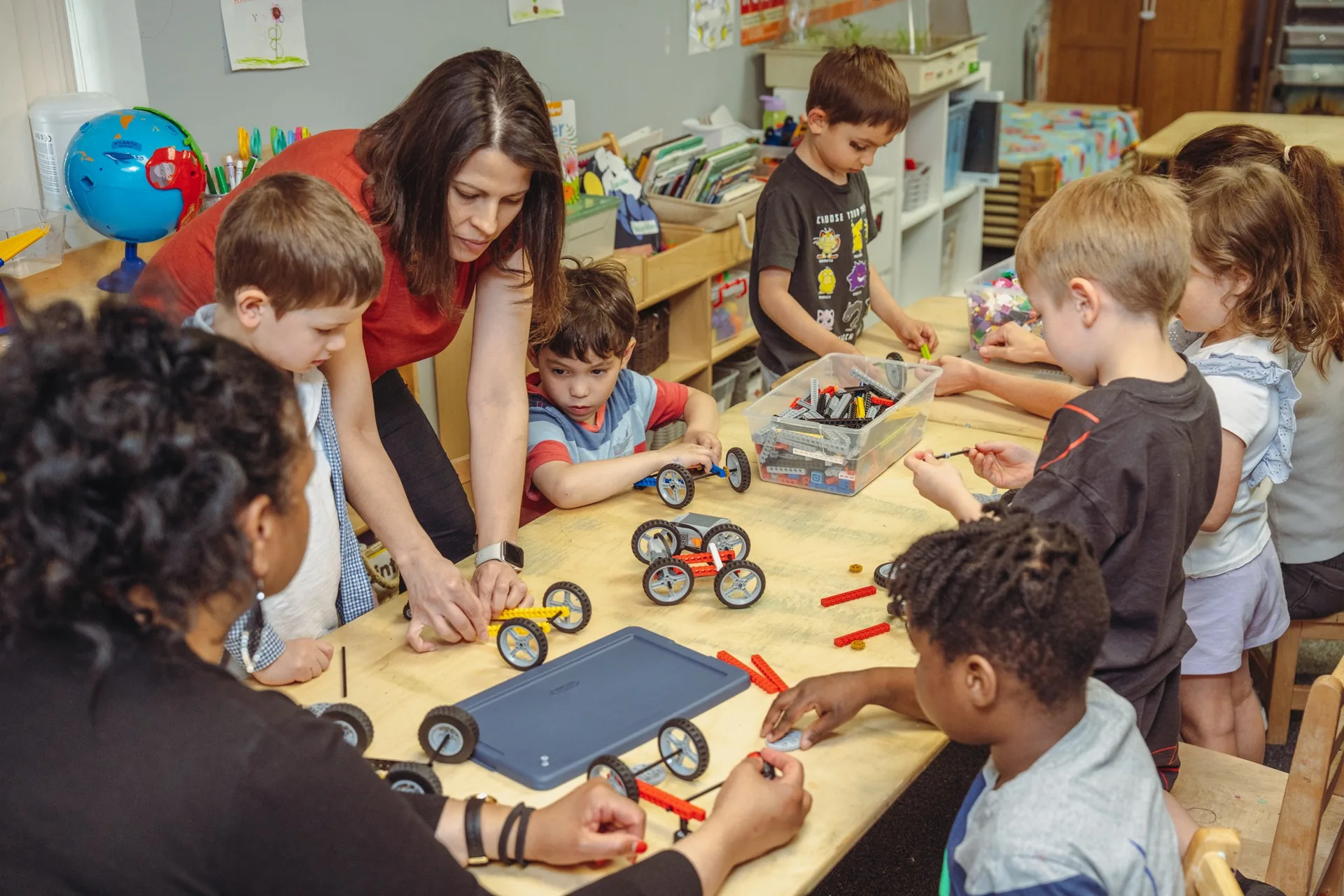 Children and teachers building and testing LEGO vehicles together