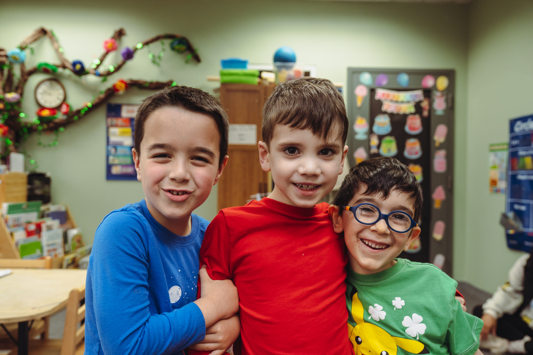 Three Pre-K friends smiling together in their classroom