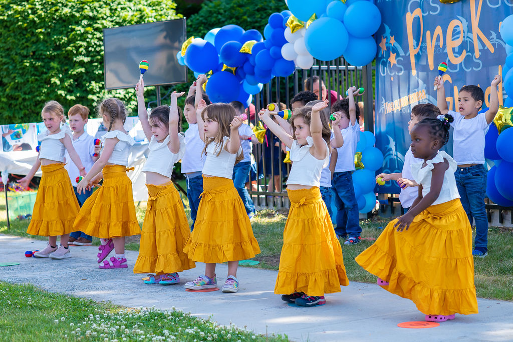Children performing music and movement together outdoors at Global Children School