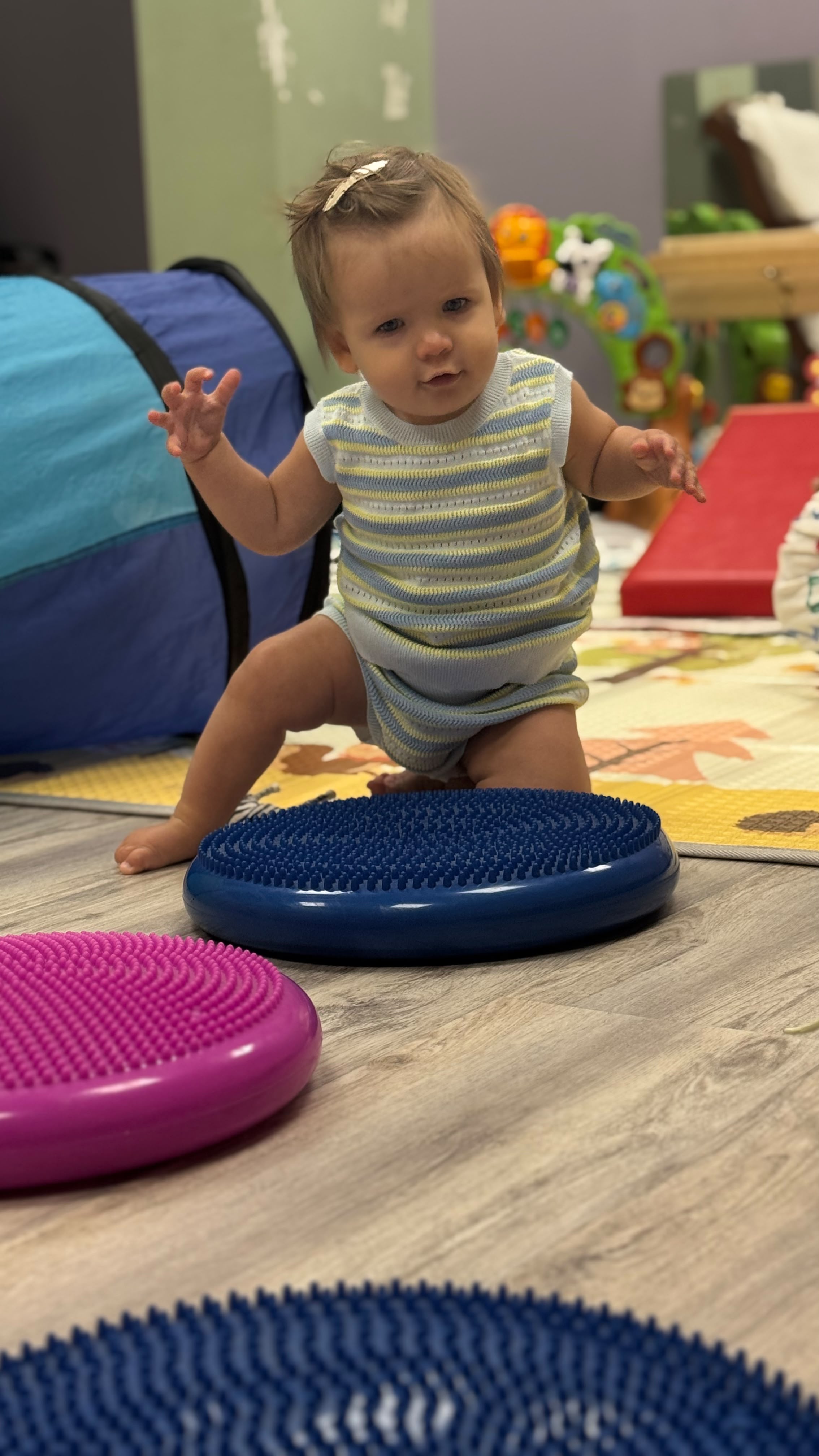 A toddler practicing balance on a sensory gym course